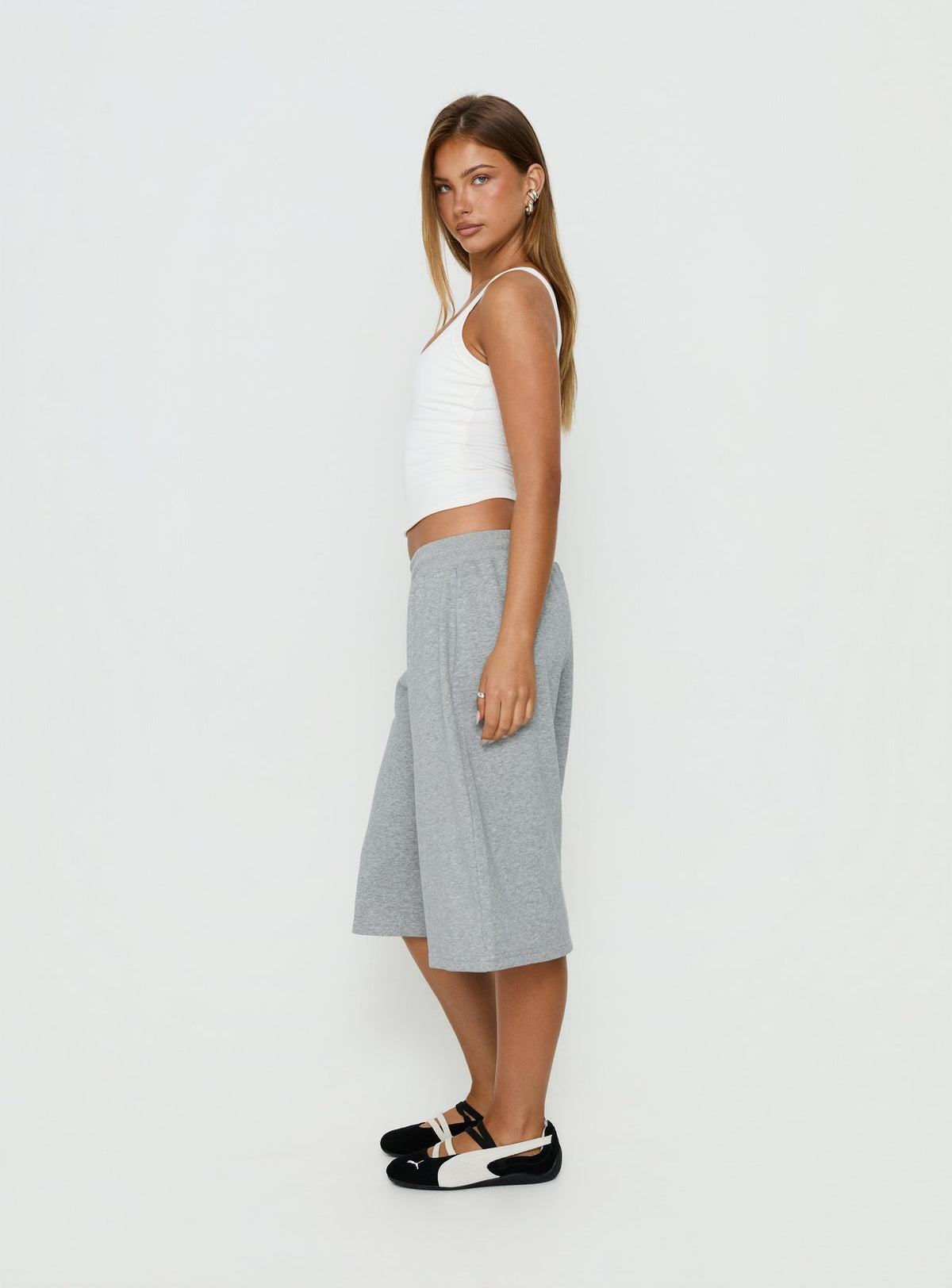 Featuring relaxed silhouette, the Nikko Longline Fleece Shorts Grey Marle in womens regular pants with mid-rise side view of model wearing Princess Polly