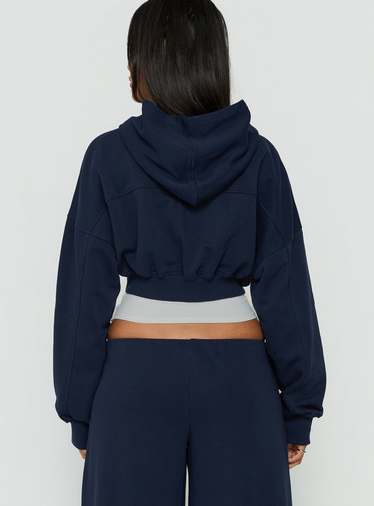 Designed with a hood, the Lanna Fleece Zip Through Cropped Hoodie Navy womens-jumpers in short length back view of model wearing Princess Polly