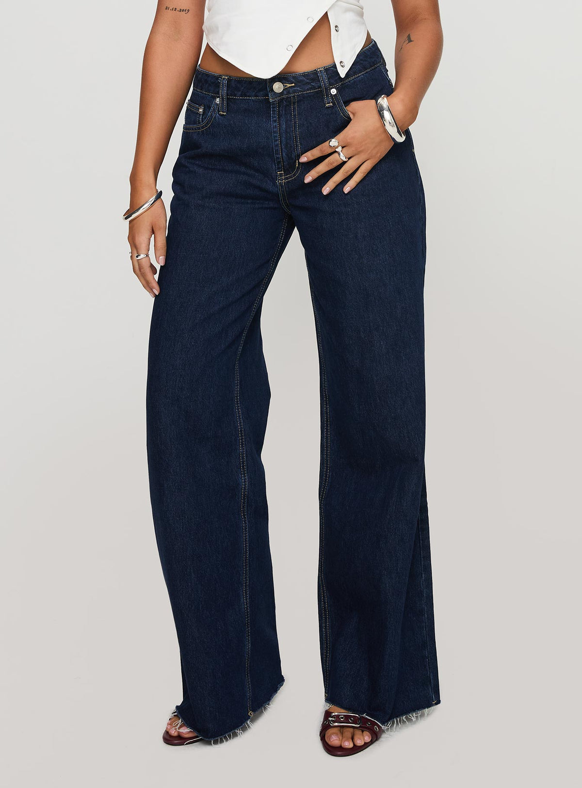 side view of model wearing Princess Polly Darla Low Rise Straight Jean Dark Wash Petite Low Rise Jeans 