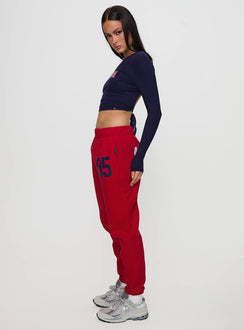 Featuring U of A Sweatpants Red in womens regular pants with mid-rise and graphic print, side view of model wearing