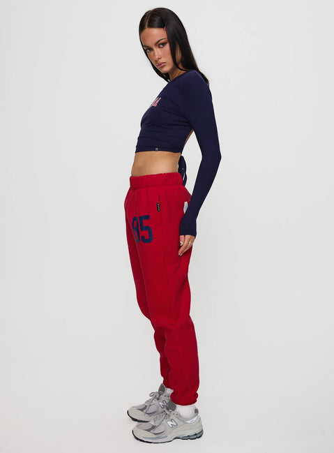 Featuring U of A Sweatpants Red in womens regular pants with mid-rise and graphic print, side view of model wearing