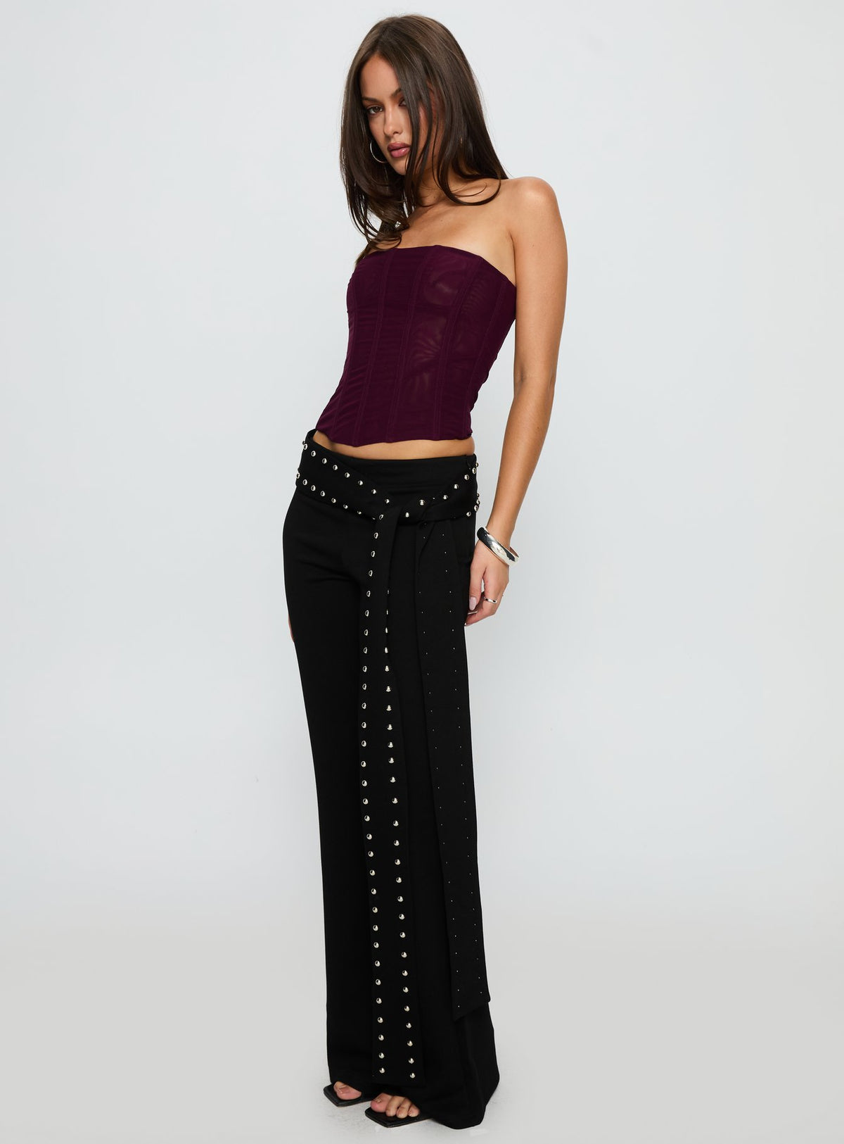 side view of model wearing Princess Polly Nikolia Studded Wrap Belt Pants Black Mid Rise Pants Pants 