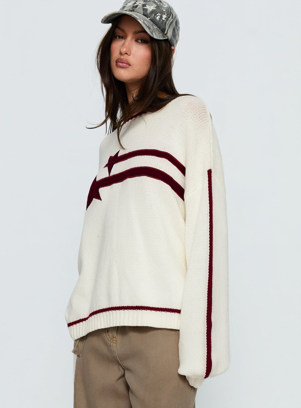 side view of model wearing Princess Polly Star Track Graphic Jumper Cream / Red Longline Jumpers Jumpers 