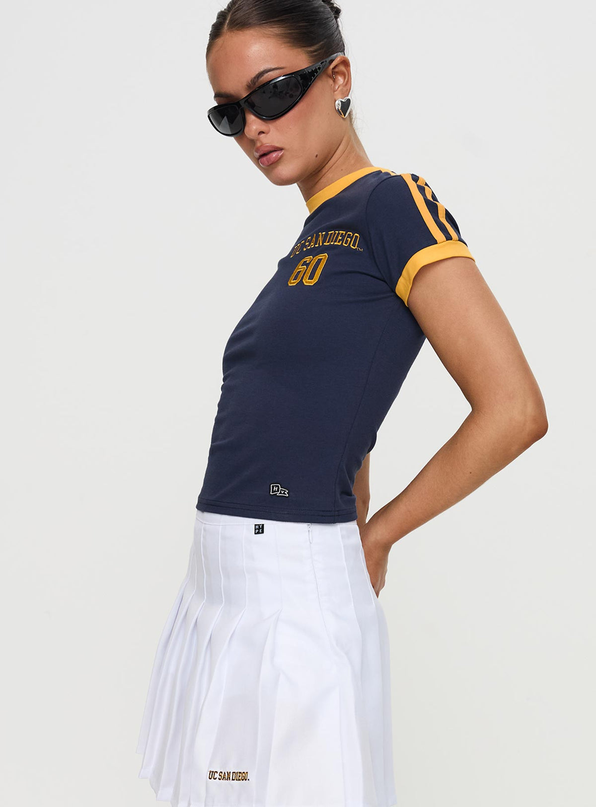 side view of model wearing Princess Polly UCSD Goalie Baby Tee Navy Short Sleeves Crew Neck 
