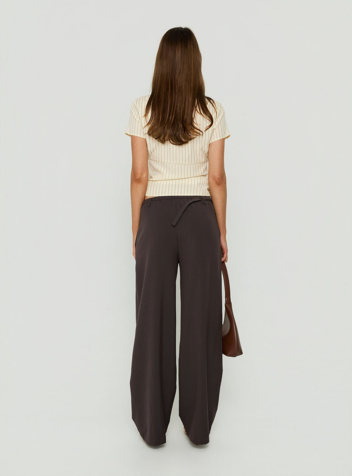 Featuring Mericana Low Rise Wide Leg Pants in Brown womens regular pants with low-rise waist back view of model wearing Princess Polly