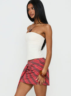   side view of model wearing Princess Polly Lindsy Tie Side Mini Skirt Red Multi Mini Skirts Skirts 