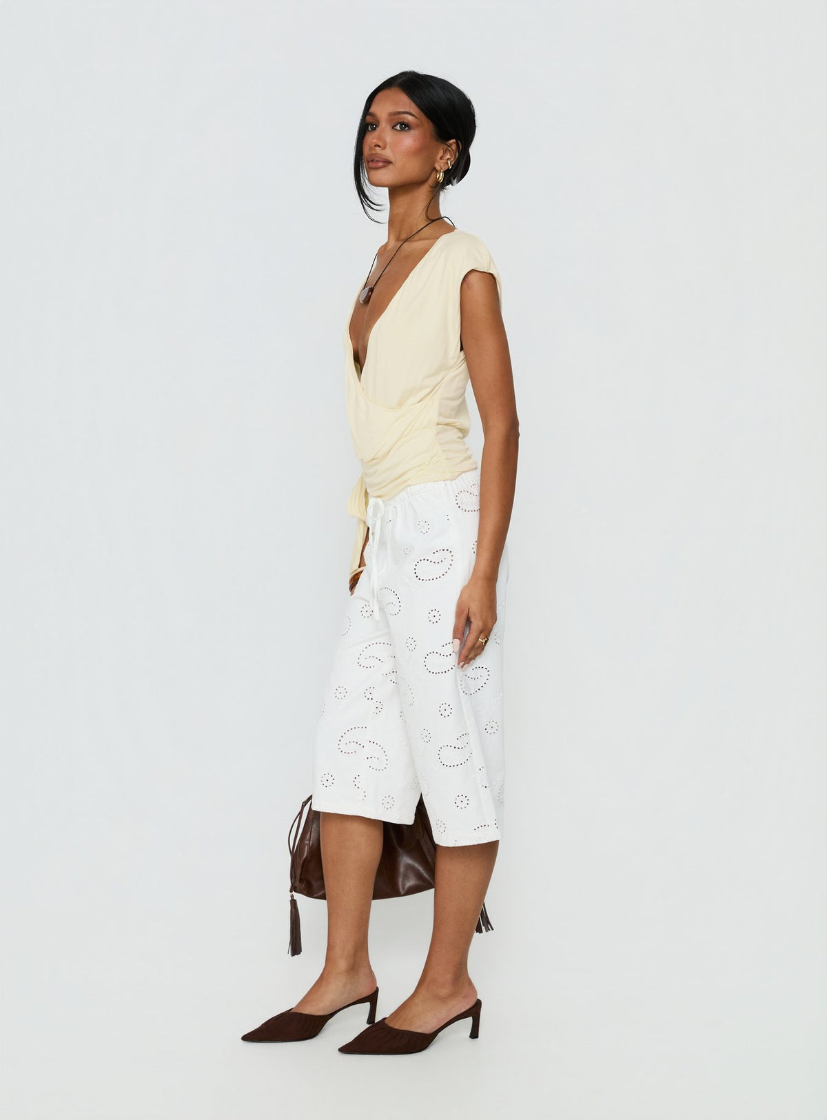 side view of model wearing Princess Polly Roda Anglaise Longline Shorts White Mid Rise Pants Pants 