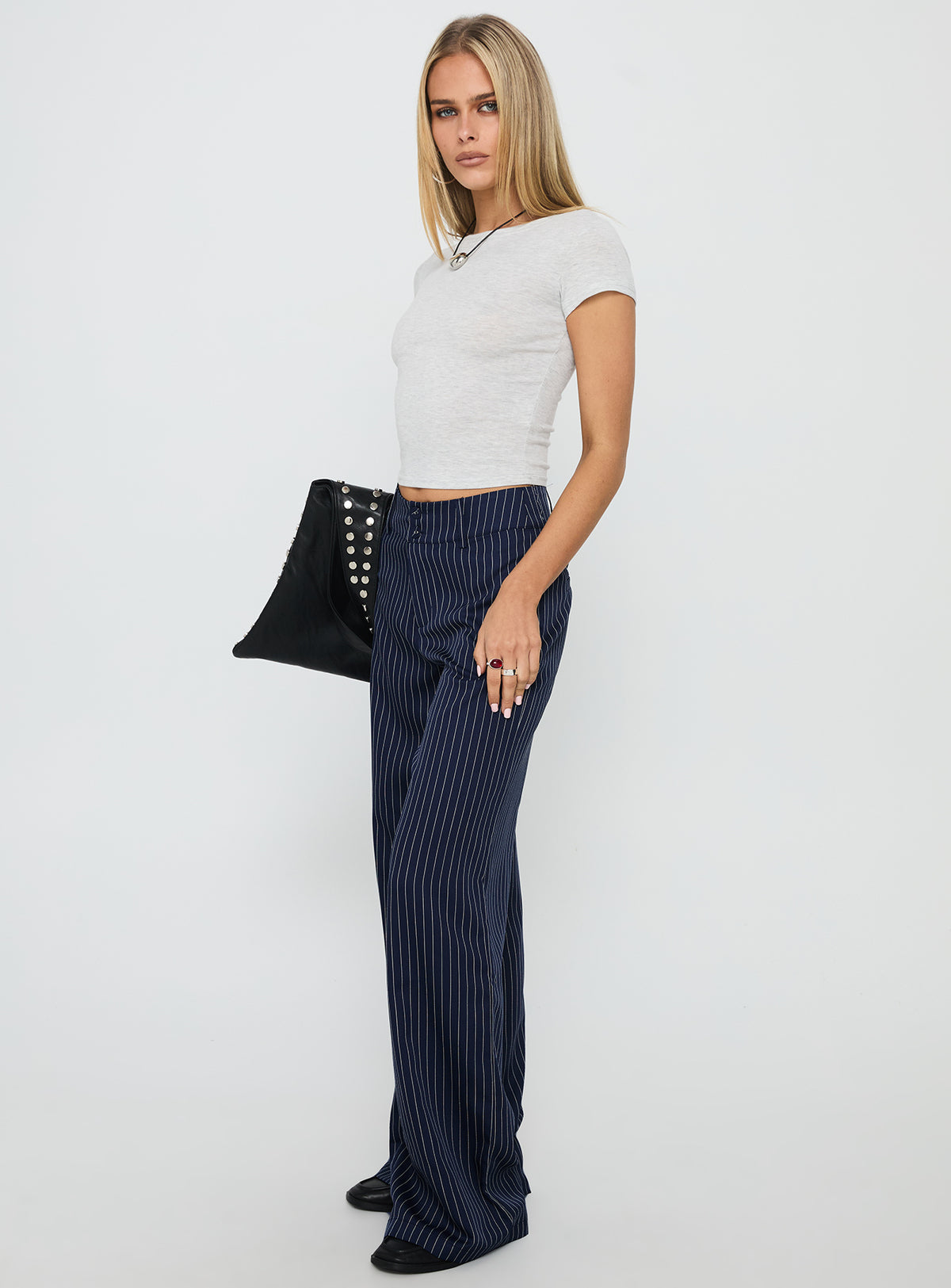 side view of model wearing Princess Polly Lorenne Mid Rise Pant Navy Pinstripe High Rise Pants Pants 