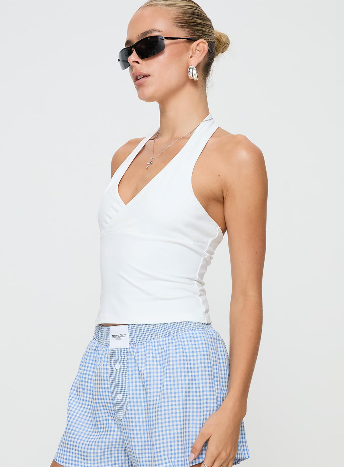 side view of model wearing Princess Polly Stand By Halter Top White Sleeveless Plunger 