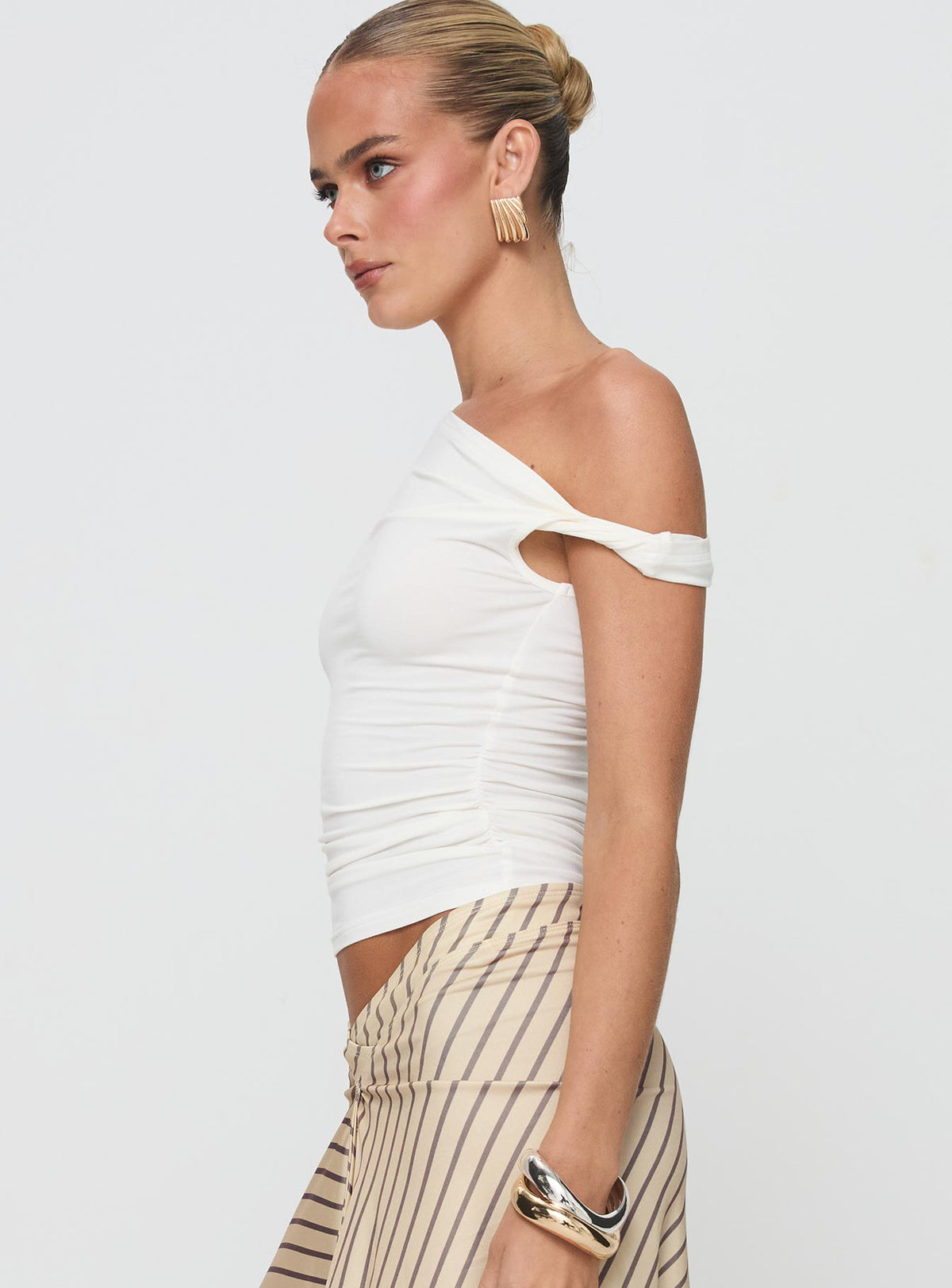 side view of model wearing Princess Polly Fabre Top White Short Sleeves Asymmetric Neckline 