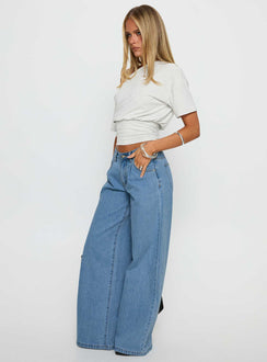 side view of model wearing Princess Polly Supercut Low Rise Baggy Pleat Jeans Light Blue Wash Low Rise Jeans Jeans 
