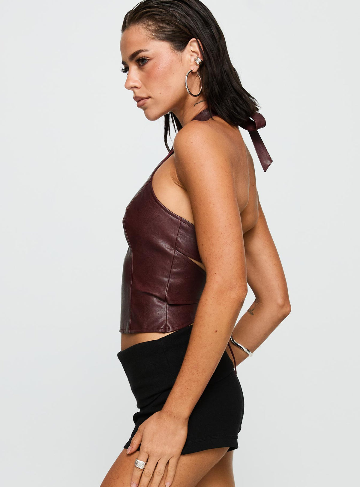 side view of model wearing Princess Polly Treat You Better Ring Detail Faux Leather Top Burgundy Sleeveless Asymmetric Neckline 