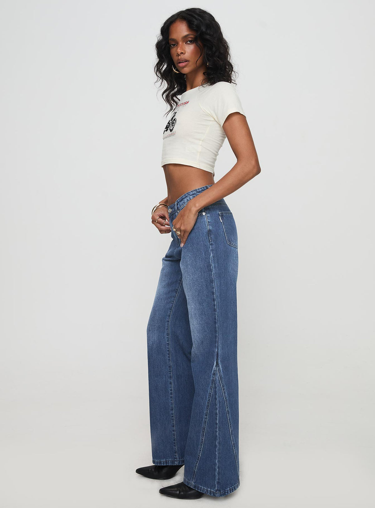side view of model wearing Princess Polly Leslee Mid Rise Flare Jean Mid Wash Blue Mid Rise Jeans Jeans 