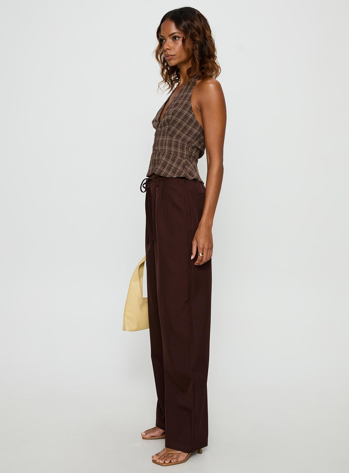 side view of model wearing Princess Polly Idolised Pleated Tie Waist Pant Chocolate Brown Mid Rise Pants 