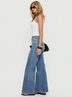 side view of model wearing Princess Polly Thearlie High Rise Flared Jeans Mid Blue Wash High Rise Jeans Jeans 