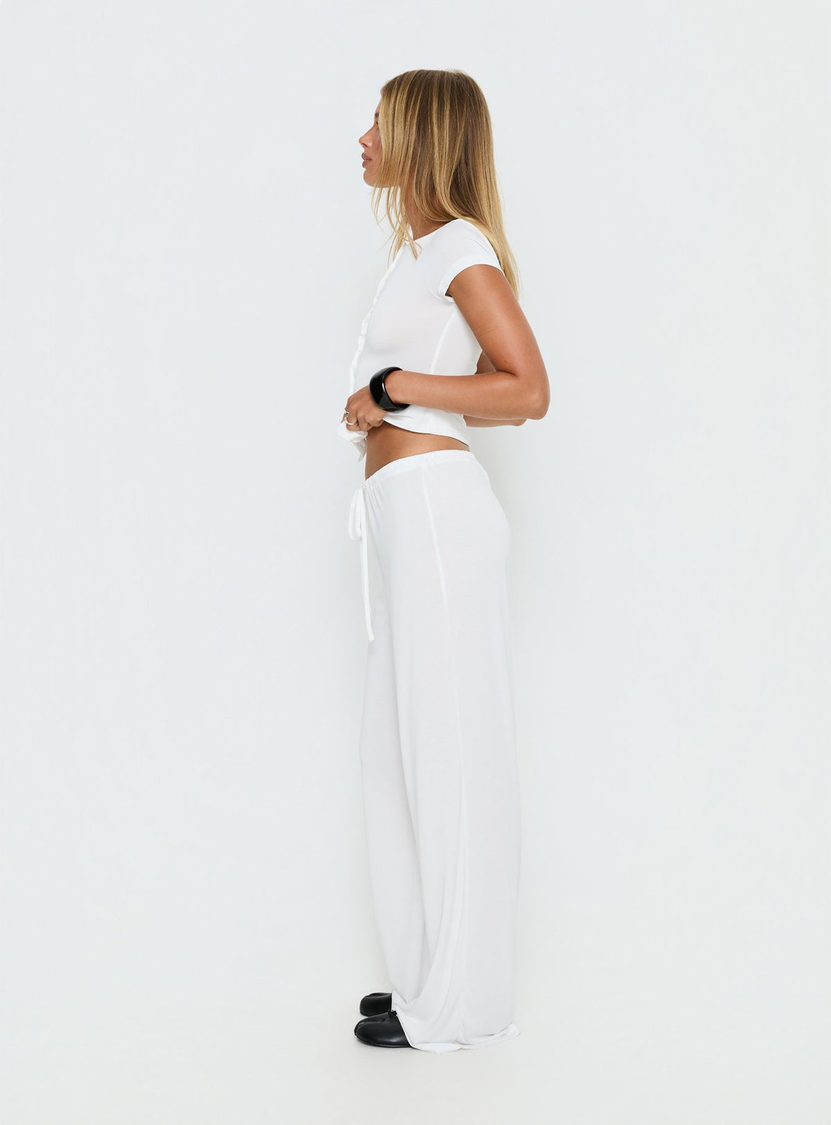 side view of model wearing Princess Polly Gavrielle Jersey Wide Leg Pants White Mid Rise Pants Pants 