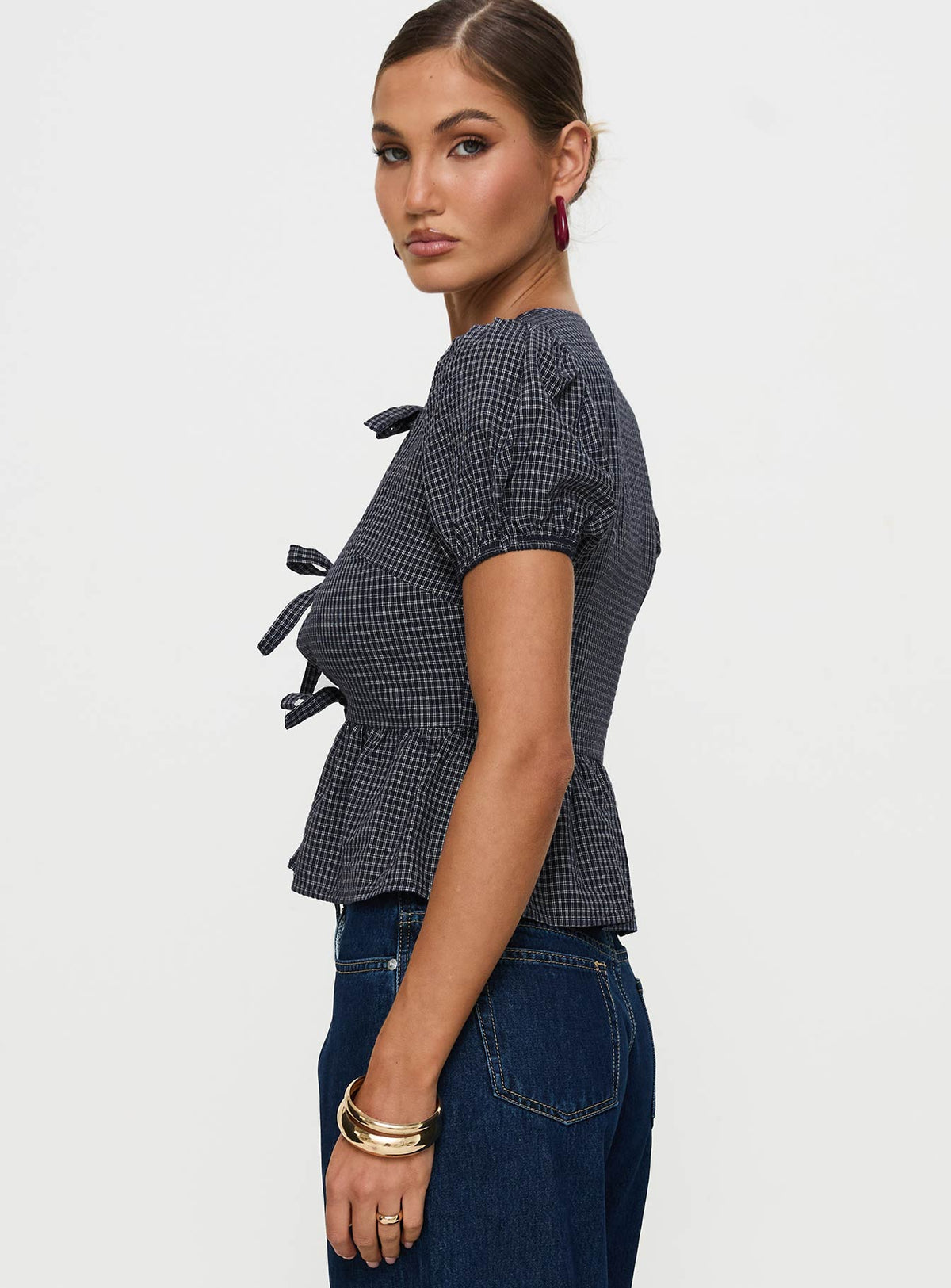 side view of model wearing Princess Polly Verah Tie Up Puff Sleeve Top Navy Check Short Sleeves Scoop Neck 