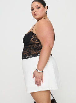 side view of model wearing Princess Polly Gigi Skort White Curve High Waisted Shorts 