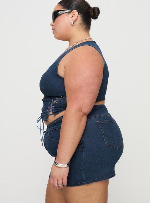   side view of model wearing Princess Polly Popular Low Rise Mini Skirt Mid Blue Wash Curve Mini Skirts Skirts 