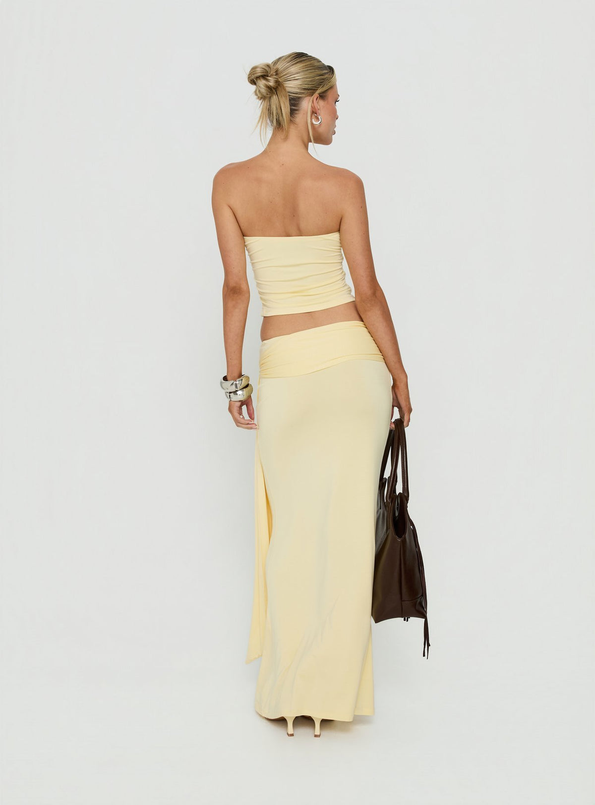 Highlighting the Aymee Tie Detail Maxi Skirt in Yellow, a women's skirt with relaxed fit, lace hem, solid print, aline shape, and wrap details back view of model wearing Princess Polly