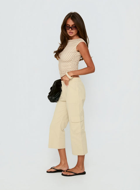 Displaying Indee Cropped Cargo Pants Beige Petite womens-regular-pants with high-rise side view of model wearing Princess Polly