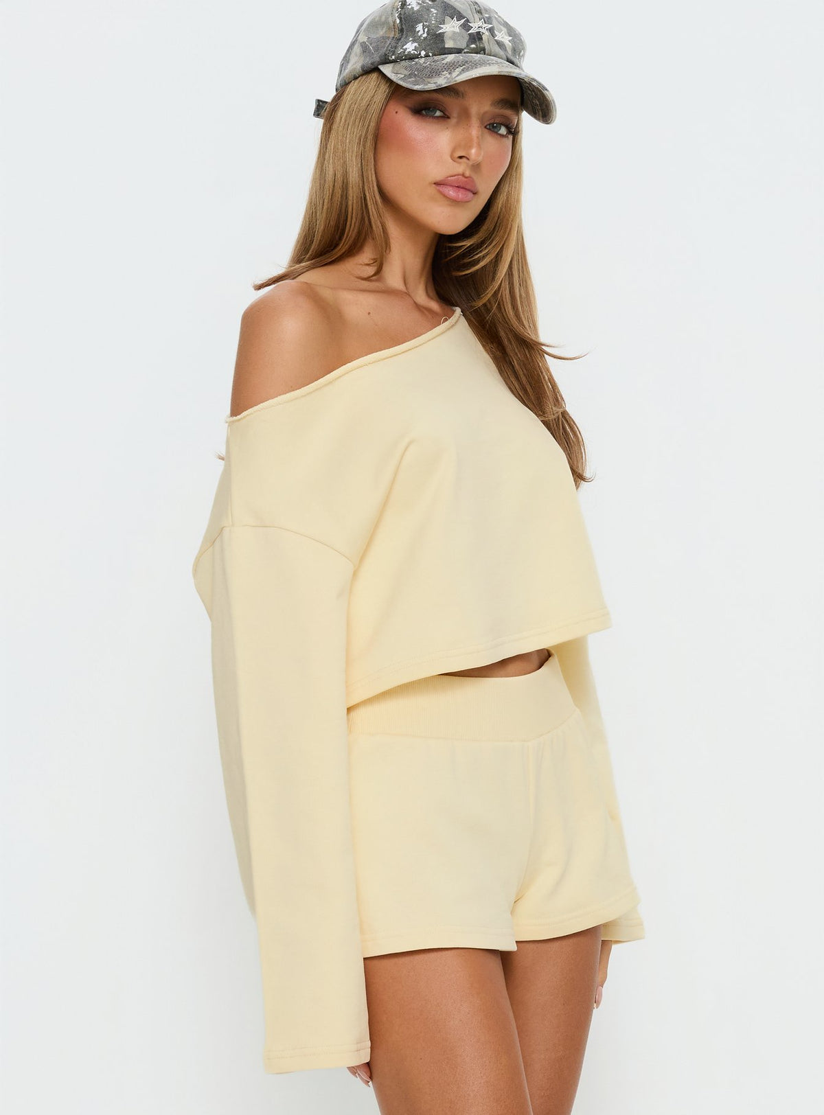 Crafted from the Retreat Raw Edge Off Shoulder Jumper Buttercream womens-jumpers with short length side view of model wearing Princess Polly