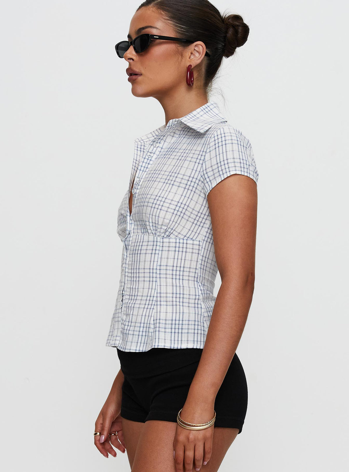 side view of model wearing Princess Polly Cottesloe Blouse Top Blue Check Short Sleeves V-Neck 
