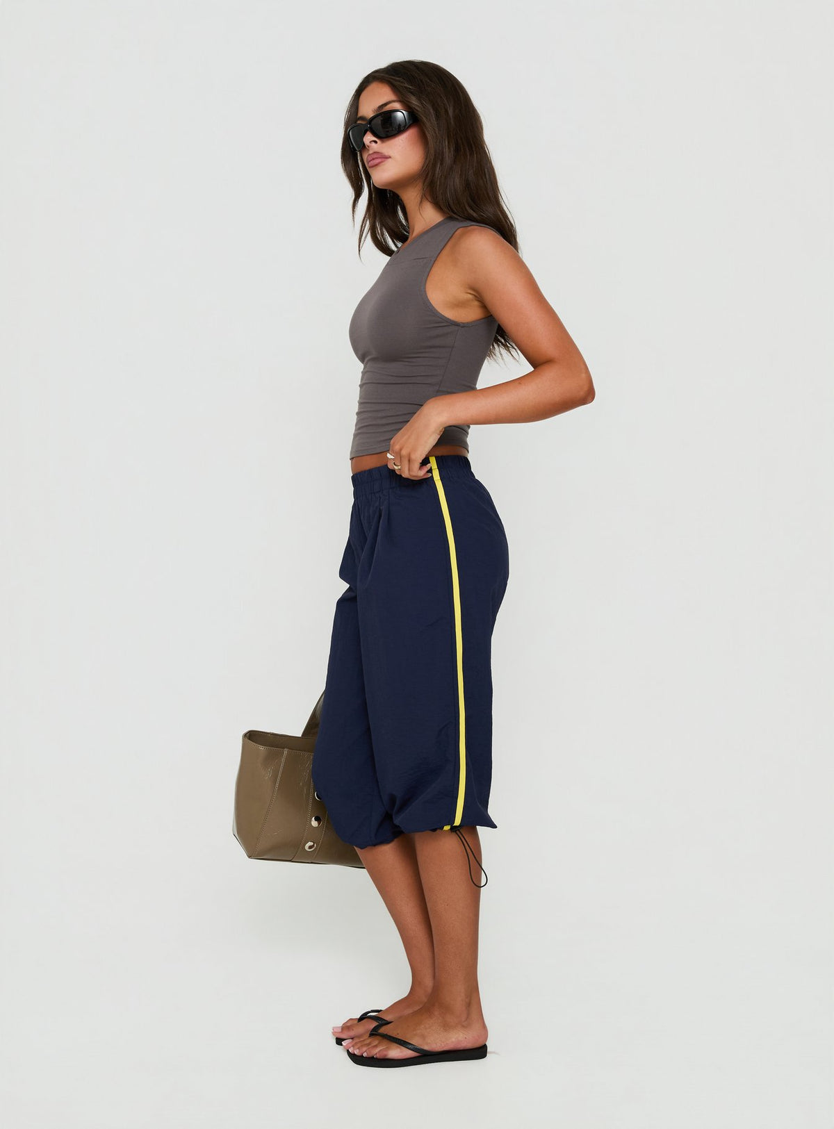 Featuring the Riyah 3/4 Low Rise Nylon Pants Navy in womens-regular-pants with striped elements side view of model wearing Princess Polly