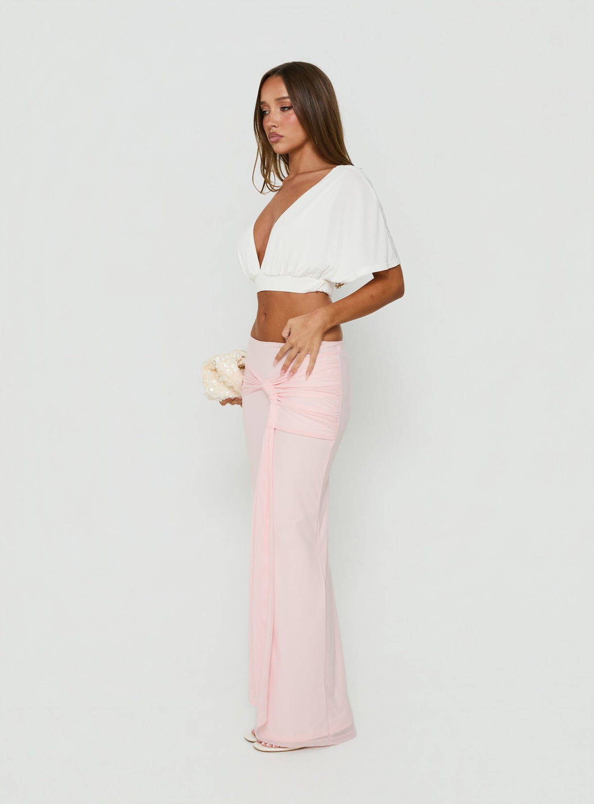 Showcasing the Isador Ruched Maxi Skirt Pink in womens-skirts with fitted a-line silhouette and solid light pink hue side view of model wearing Princess Polly