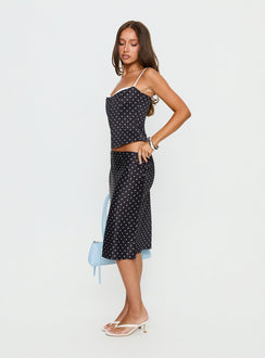 Showcasing the Somani Satin Midi Skirt Black Polka Dot womens-skirts in midi length side view of model wearing