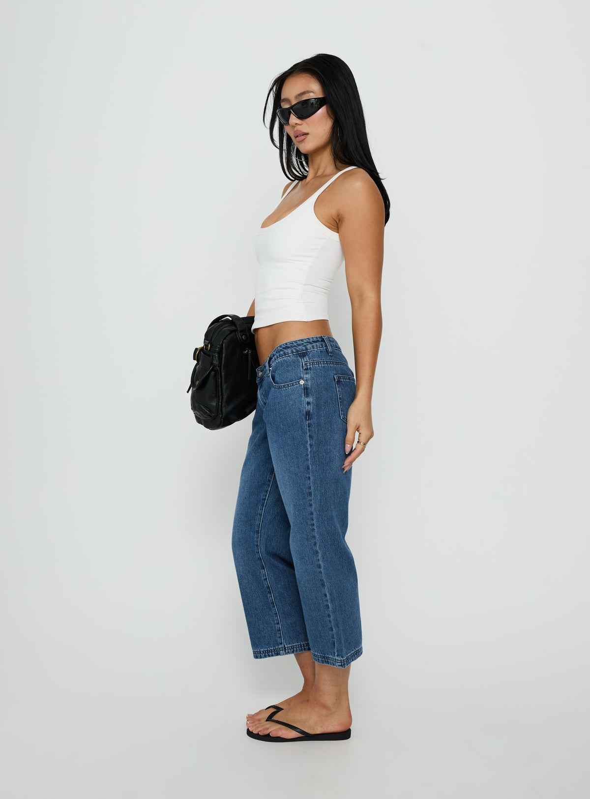 Crafted with style, the Hierarchy Low Rise 3/4 Length Jeans Mid Wash womens-jeans side view of model wearing Princess Polly