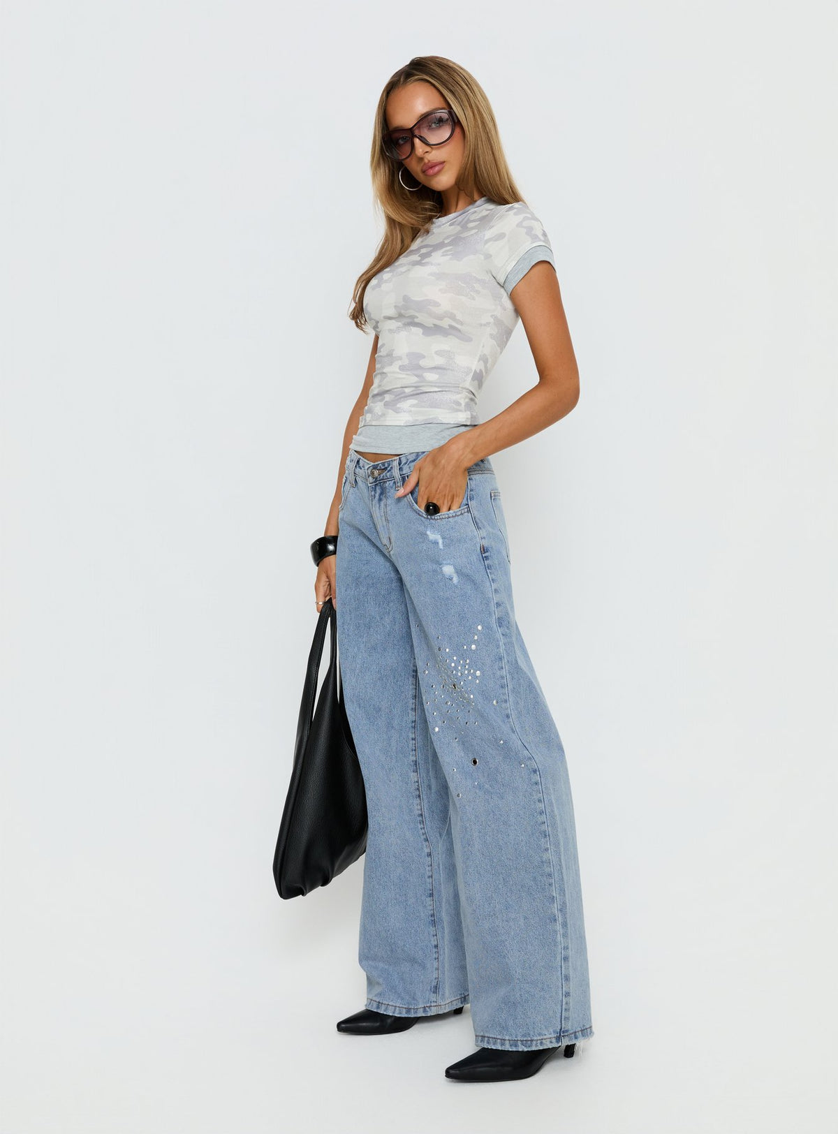 Designed with Candi Mid Rise Wide Leg Studded Jeans in a light blue wash, womens-jeans featuring mid-rise waist side view of model wearing Princess Polly