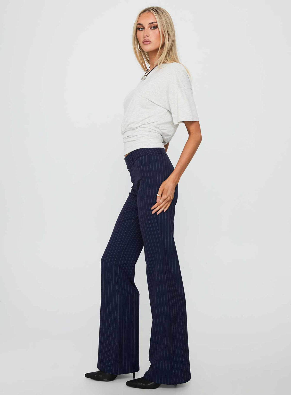 side view of model wearing Princess Polly Kinkirk Flared Pants Navy Pinstripe Low Rise Pants Pants 