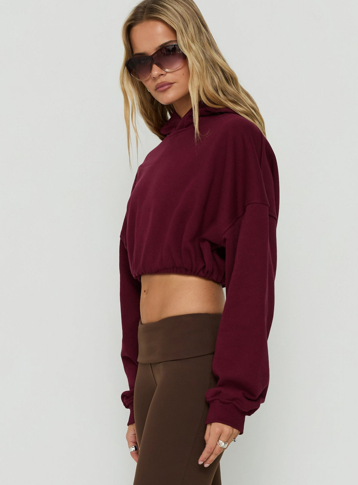 Explore the Mayse Bubble Hem Cropped Hoodie Cherry womens-jumpers with short length side view of model wearing Princess Polly