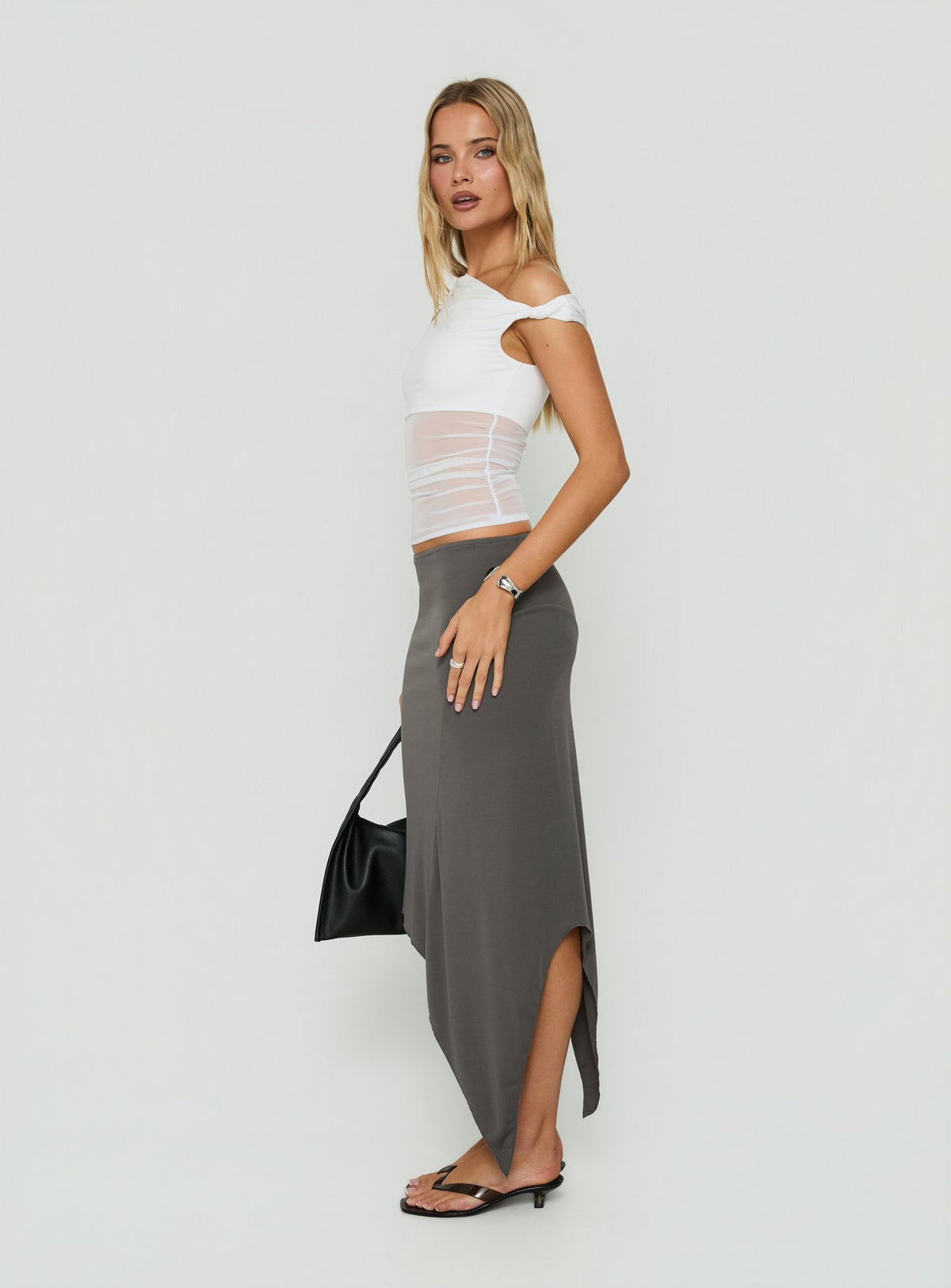 Featuring the Aviza Asymmetrical Midi Skirt Grey in womens-skirts with fitted style side view of model wearing Princess Polly