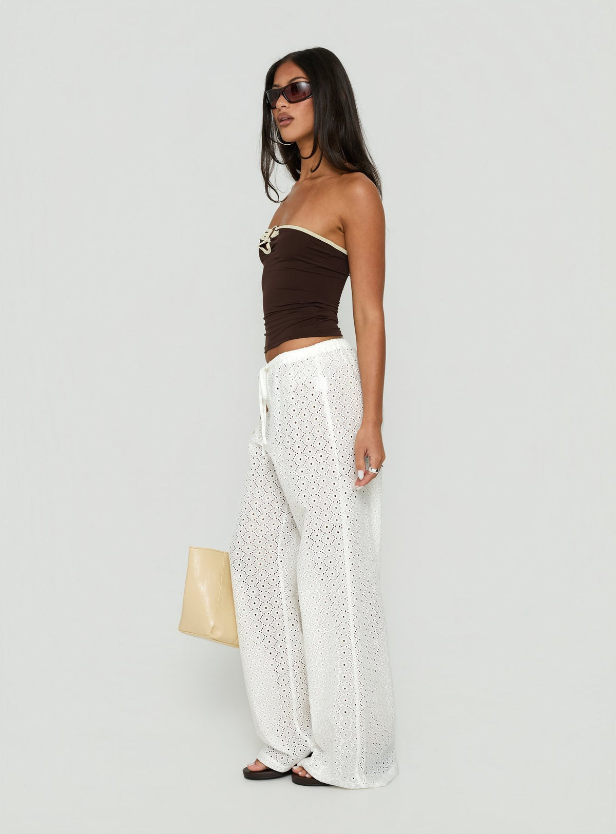 Displaying the Lindora Drawstring Wide Leg Pants White Broderie in womens-regular-pants with mid-rise waist side view of model wearing Princess Polly