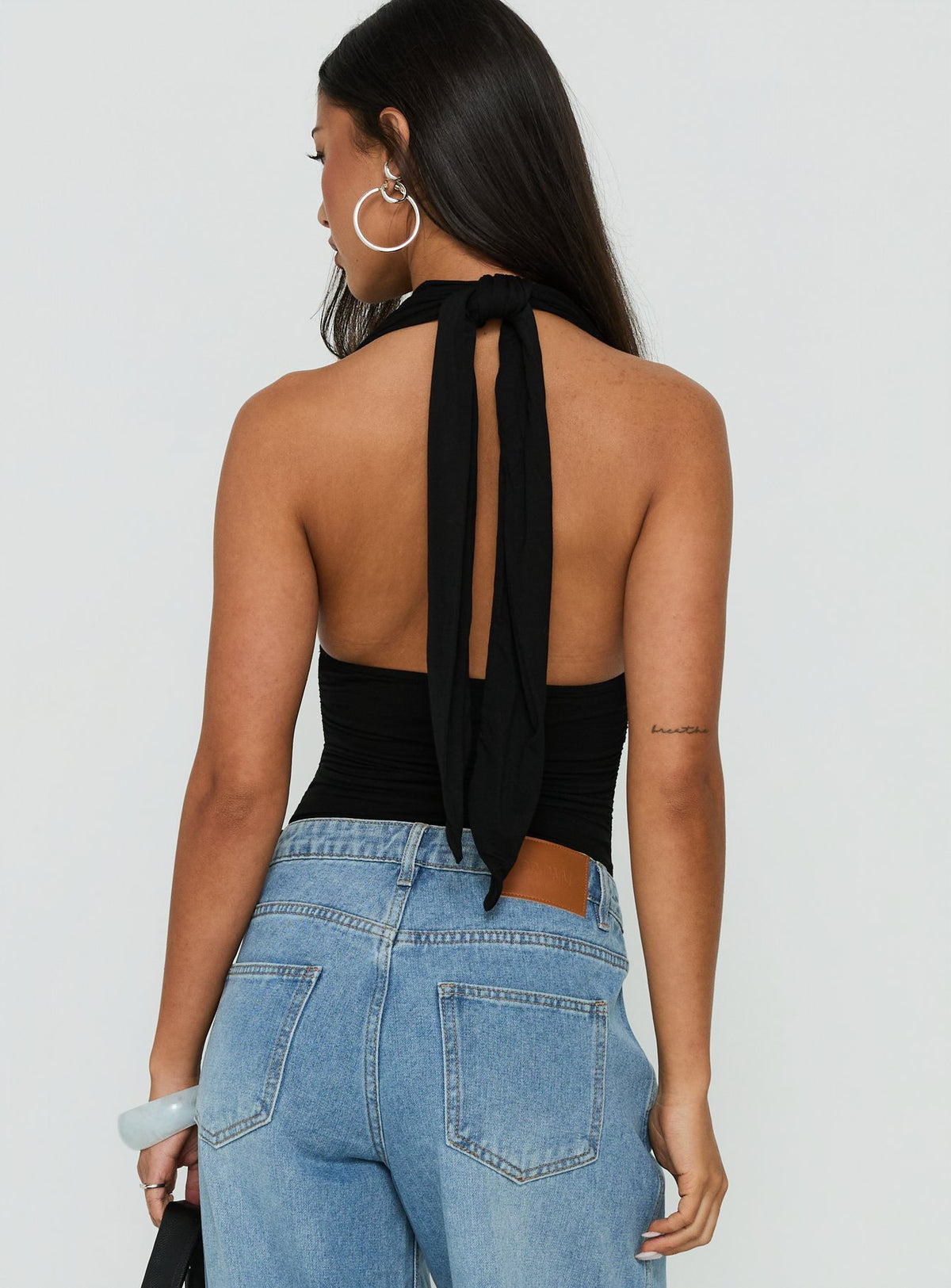 Crafted with style the Celinna Multi Wear Bodysuit in sleeveless black with plunge halter neckline and ruched details back view of model wearing