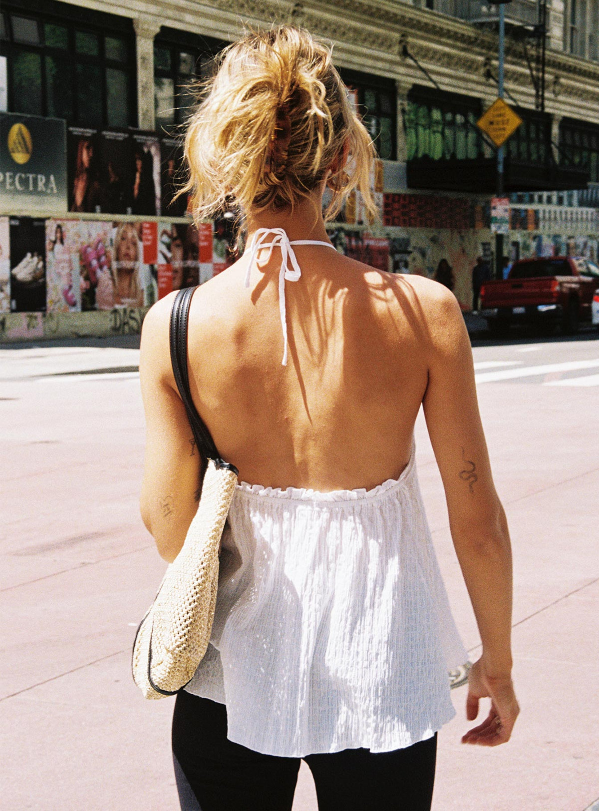 back view of model wearing Princess Polly Flutter Halter Top White Sleeveless High Neck 