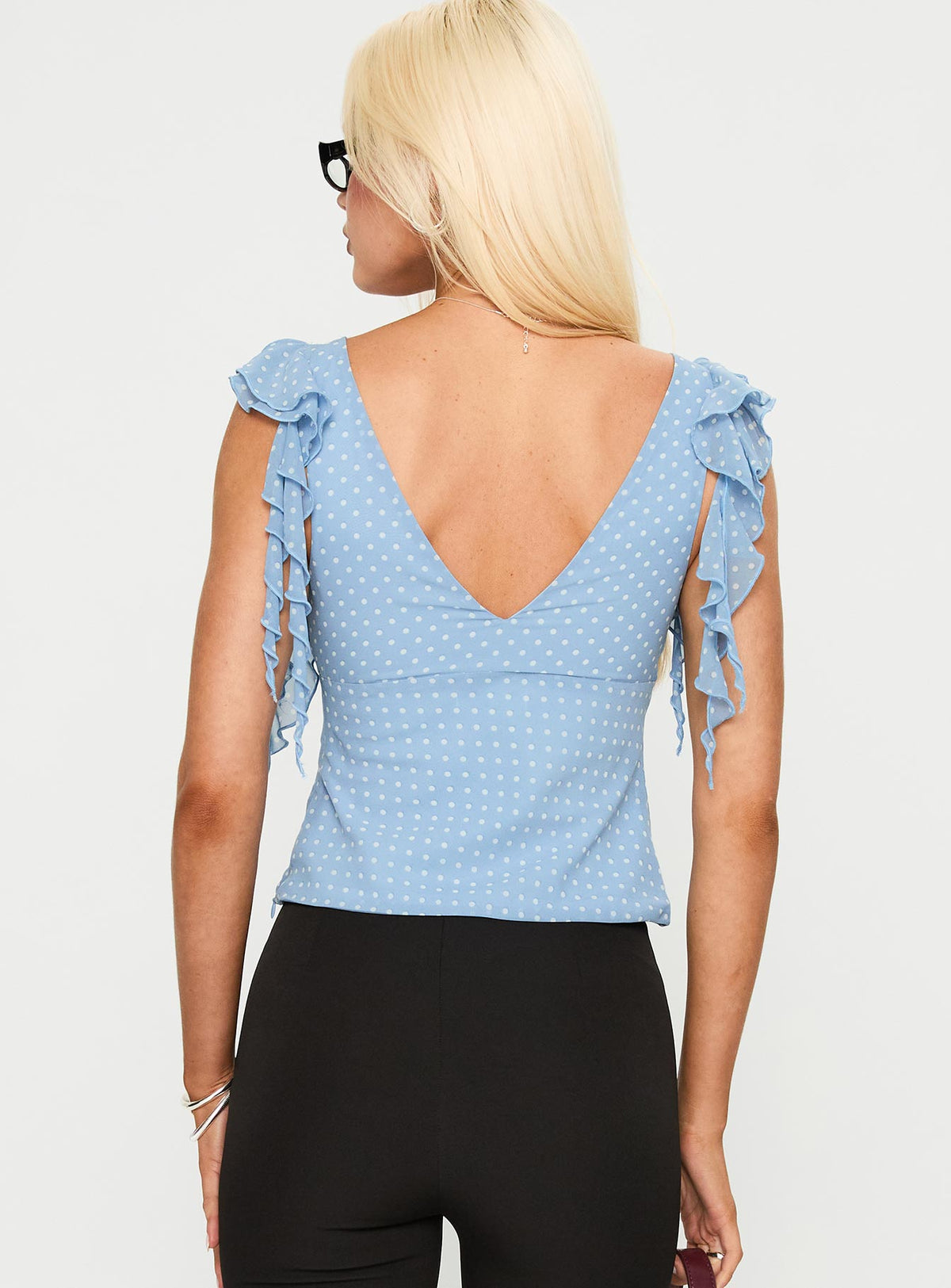 back view of model wearing Princess Polly Miztry Top Blue Polka Sleeveless Plunger 