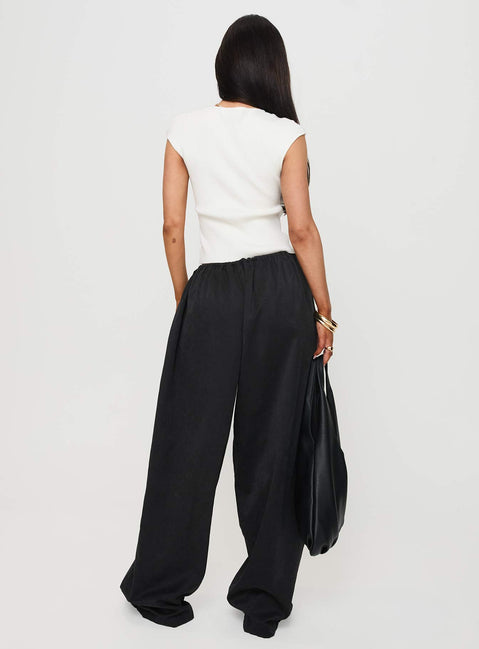 Presenting the Bungala Oversized Relaxed Pants Black Tall wide-leg womens regular pants in mid-rise back view of model wearing Princess Polly