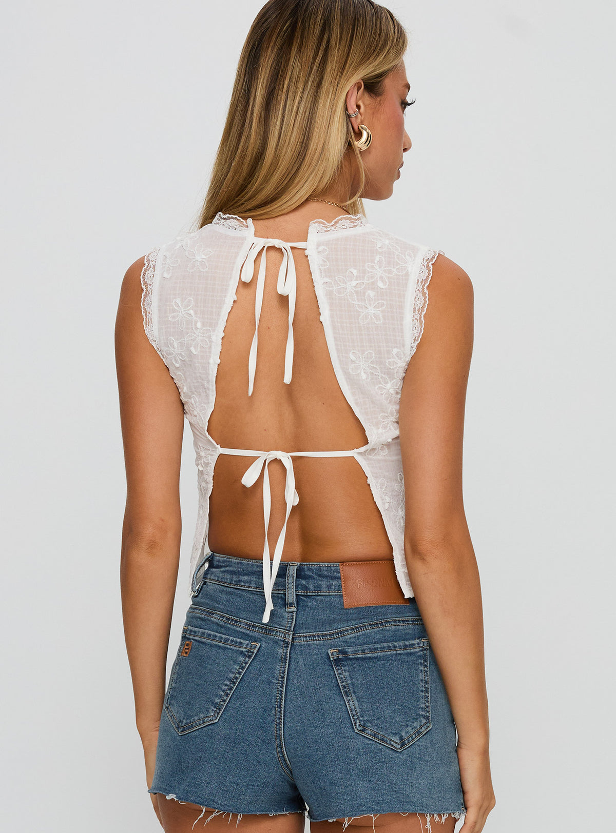 back view of model wearing Princess Polly Hagea Top White Sleeveless Plunger 
