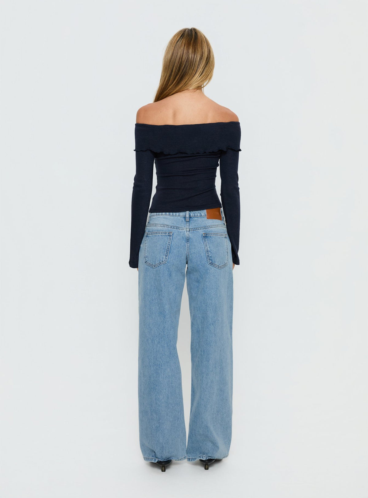 Displaying the Ellanor Low Rise Slouch Denim Jean Washed Mid Blue Wash Tall womens-jeans back view of model wearing Princess Polly