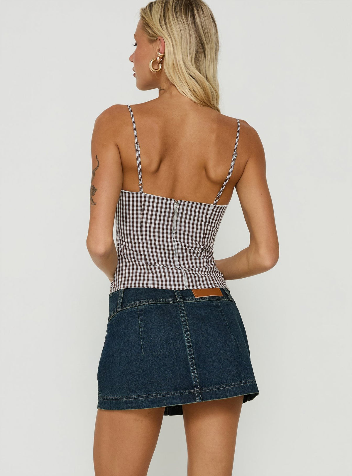 Highlighting the Ladena Mid Rise Double Button Mini Skirt Raw Denim womens-skirts back view of model wearing Princess Polly