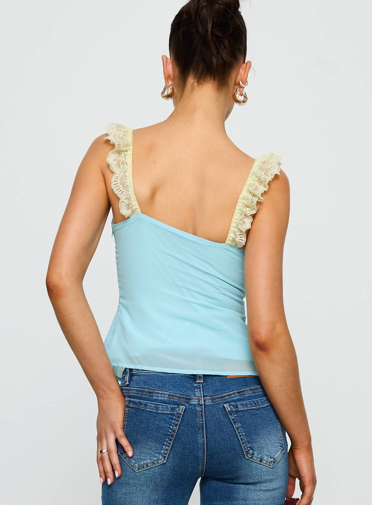 back view of model wearing Princess Polly Delvonte Top Blue / Yellow Sleeveless V-Neck 