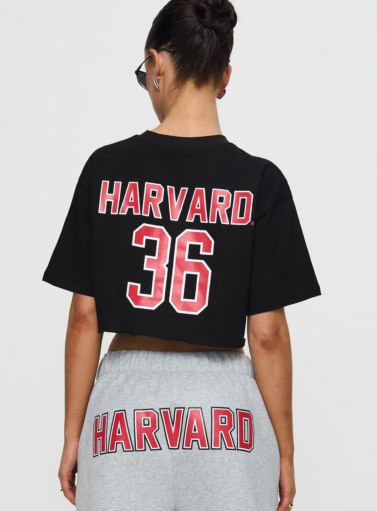 back view of model wearing Princess Polly Harvard Graphic Track Top Black Short Sleeves Crew Neck 
