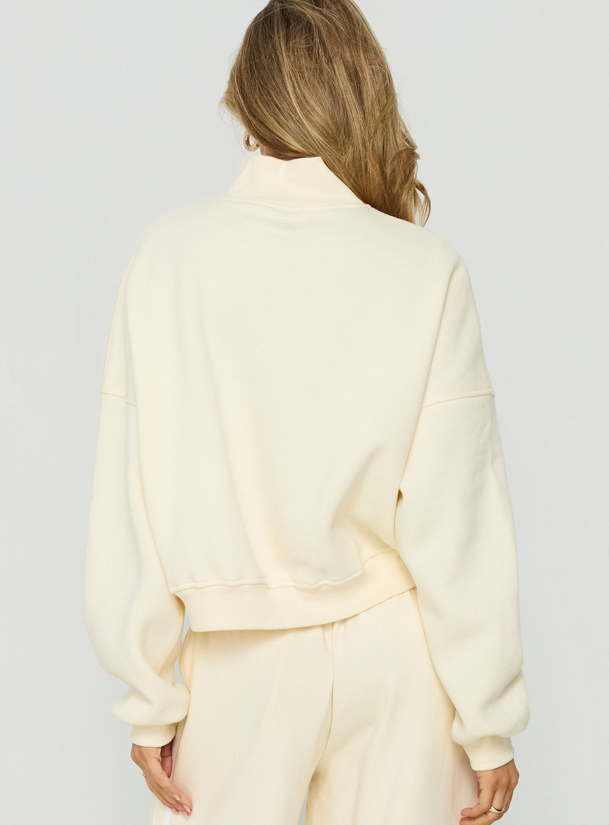 Designed with high neckline the Anyya Funnel Neck Crew Jumper Cream short womens jumper back view of model wearing Princess Polly