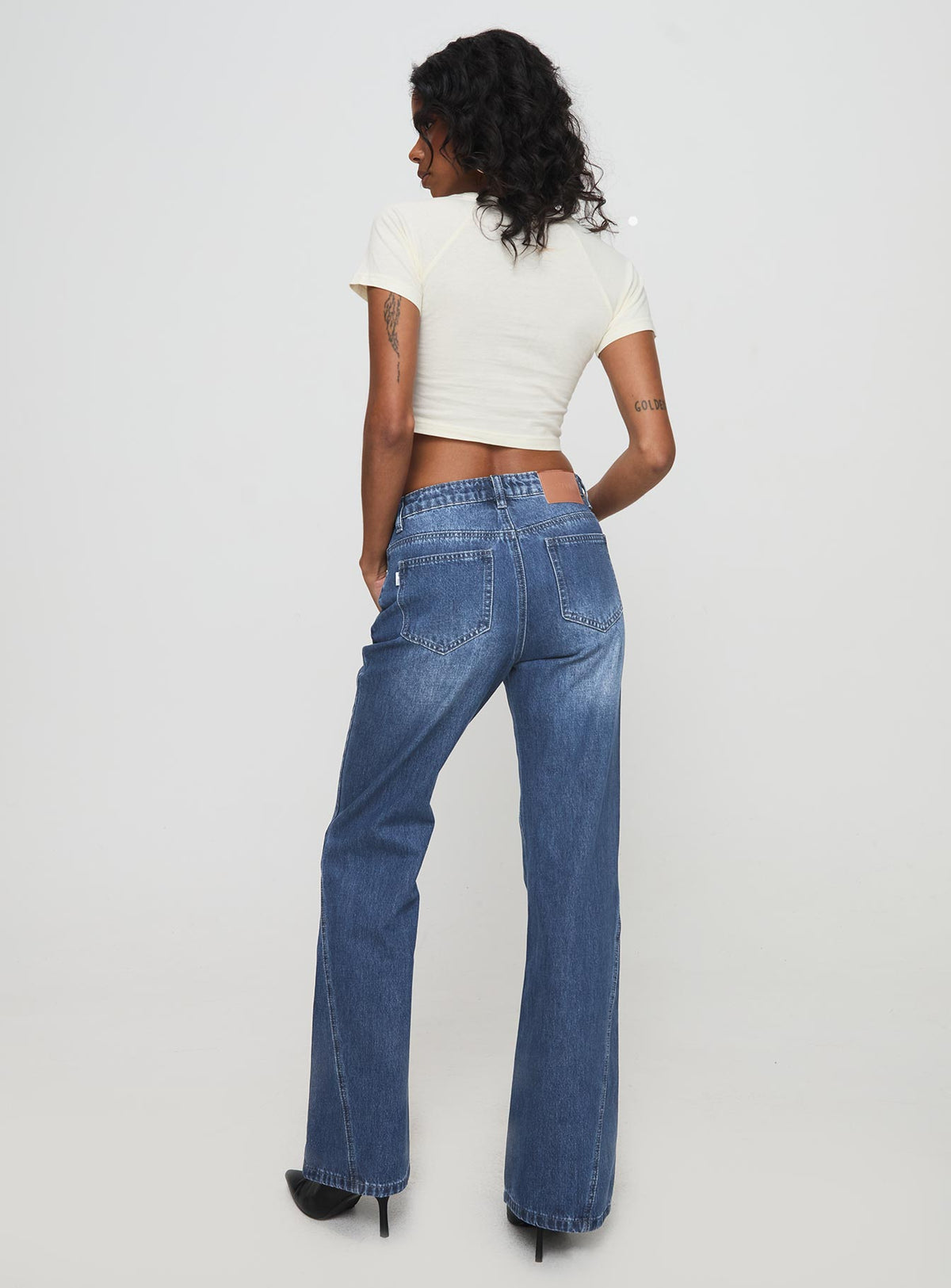 back view of model wearing Princess Polly Leslee Mid Rise Flare Jean Mid Wash Blue Mid Rise Jeans Jeans 