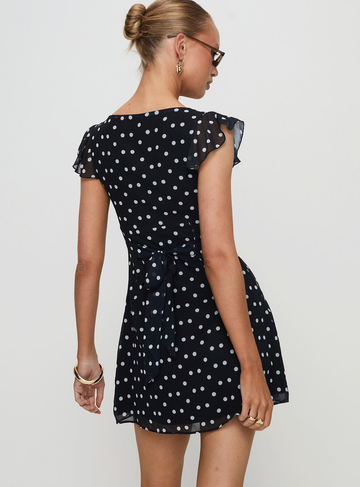 back view of model wearing Princess Polly I Guess So Mini Dress Black Polka Dot Tall V-Neck 