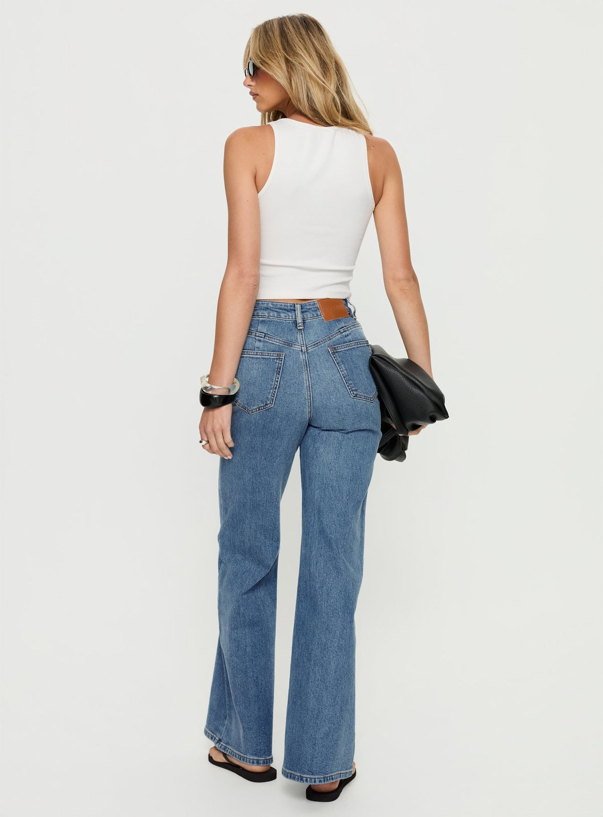 back view of model wearing Princess Polly Thearlie High Rise Flared Jeans Mid Blue Wash High Rise Jeans Jeans 