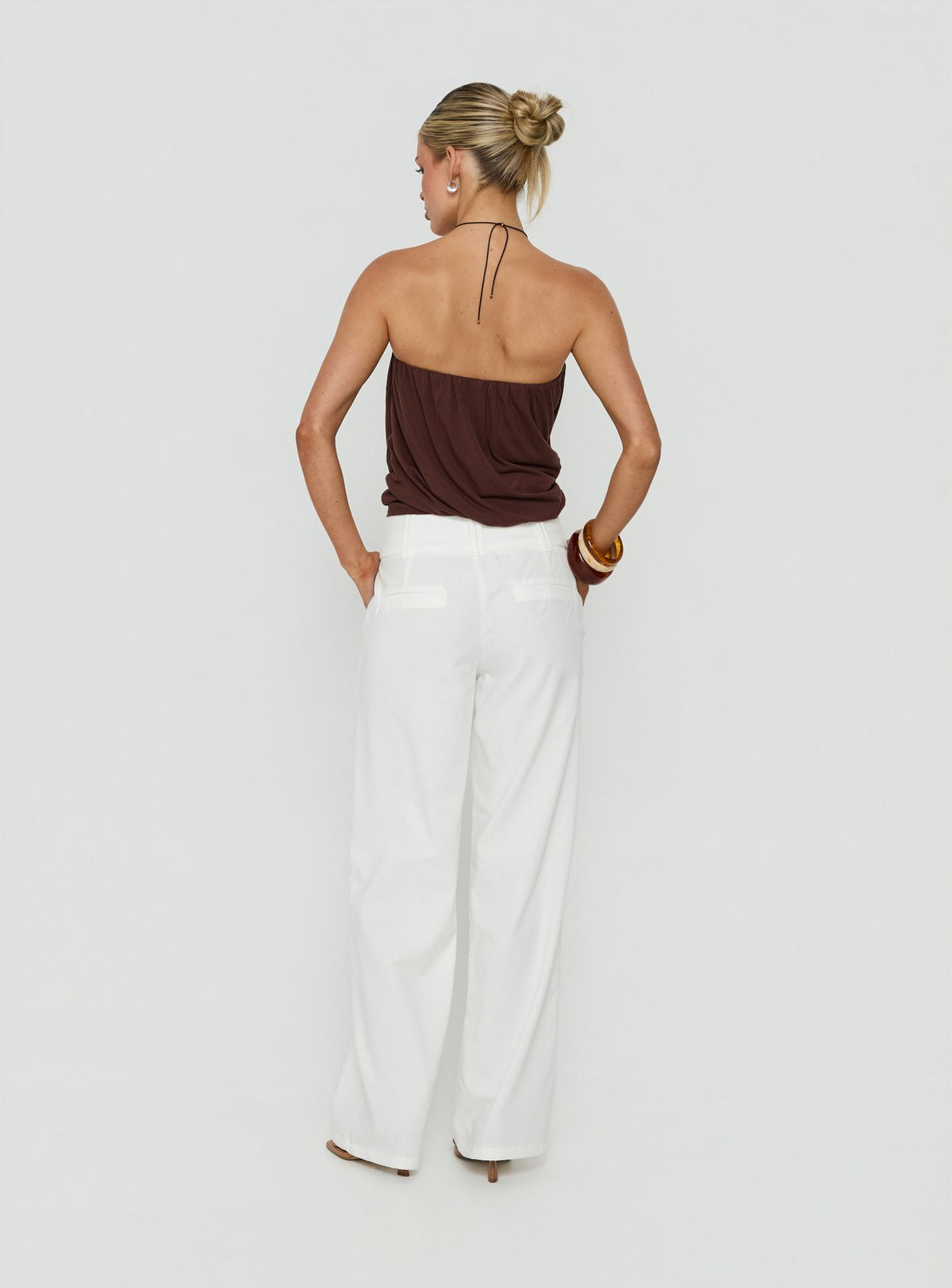 Designed with the Two Lovers Linen Low Rise Pants White in womens regular pants, showcasing wide-leg silhouette and low-rise fit, back view of model wearing